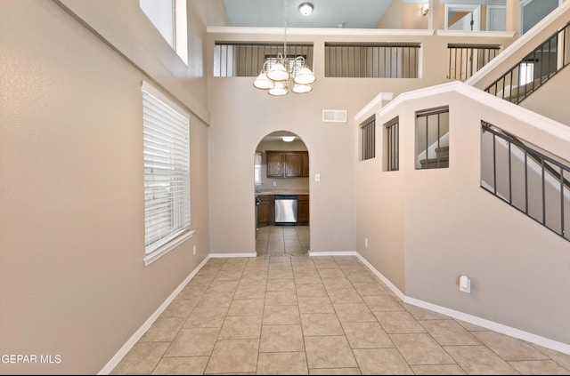 12482 Paseo Rojo Dr, El Paso, TX 79928 - hall featuring a notable chandelier, baseboards, light tile patterned floors, visible vents, and arched walkways