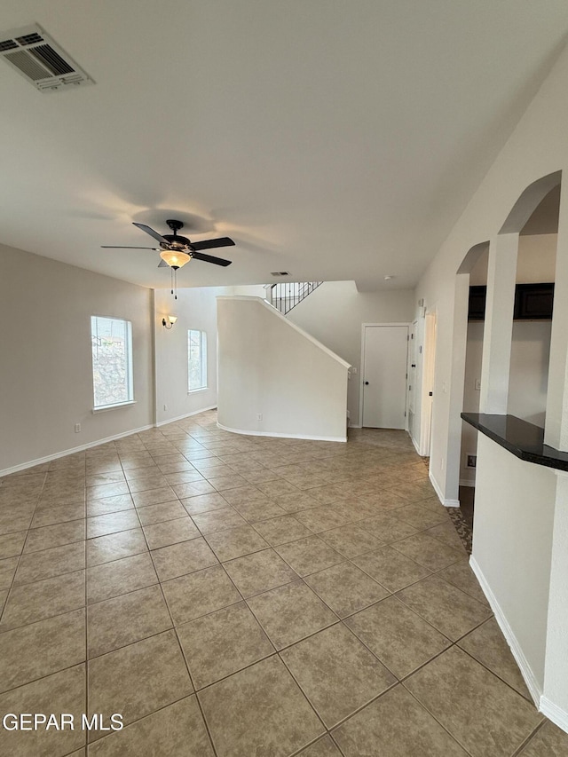 14368 N Cave Dr, El Paso, TX 79938 - tiled spare room featuring visible vents, baseboards, a ceiling fan, and arched walkways
