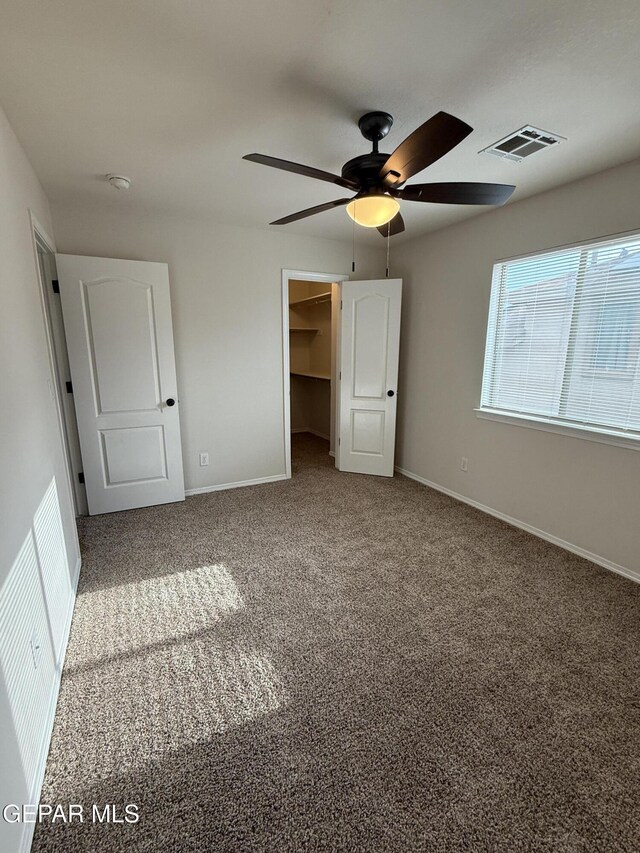 14368 N Cave Dr, El Paso, TX 79938 - unfurnished bedroom featuring baseboards, a spacious closet, carpet flooring, visible vents, and ceiling fan
