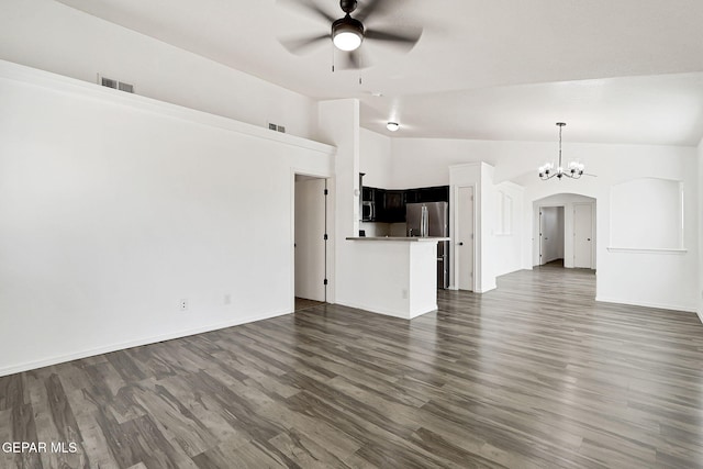 12729 Raul Mendiola Ln, El Paso, TX 79938 - unfurnished living room featuring a ceiling fan, vaulted ceiling, arched walkways, dark wood-style floors, and a chandelier