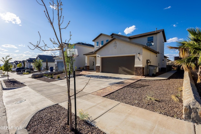 traditional home with driveway, an attached garage, stucco siding, and stone siding