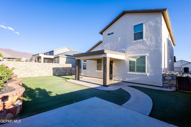 back of house featuring stucco siding and a patio area