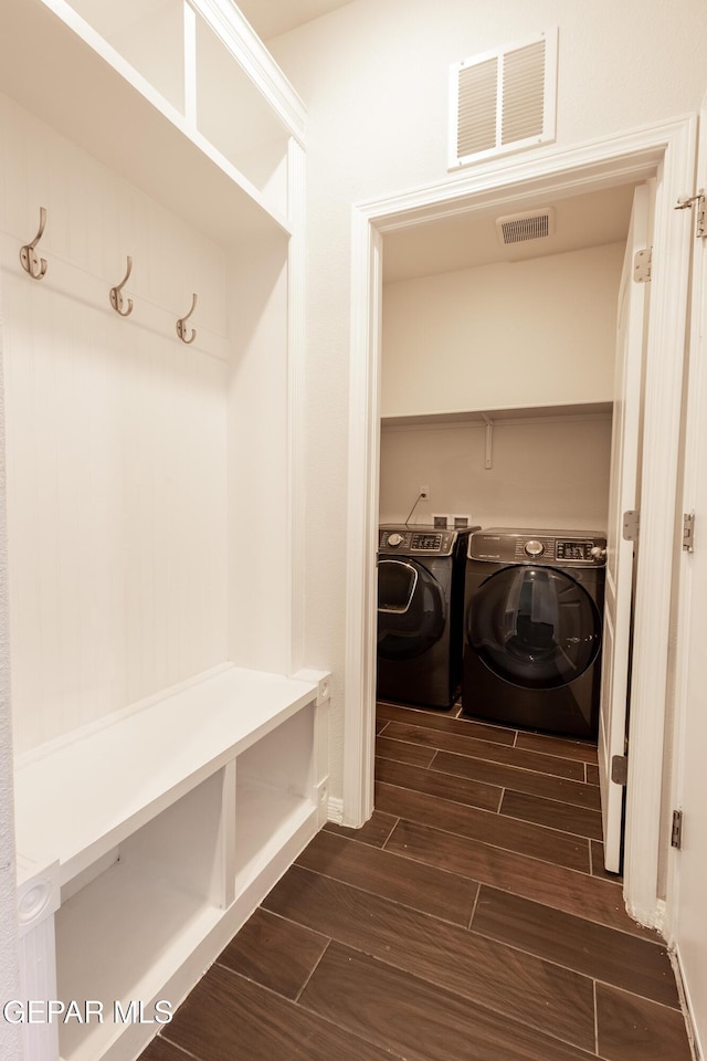 laundry room featuring washing machine and dryer and wood finish floors