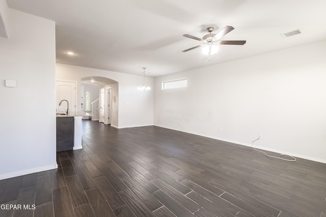 empty room with arched walkways, a ceiling fan, dark wood-style flooring, a sink, and recessed lighting