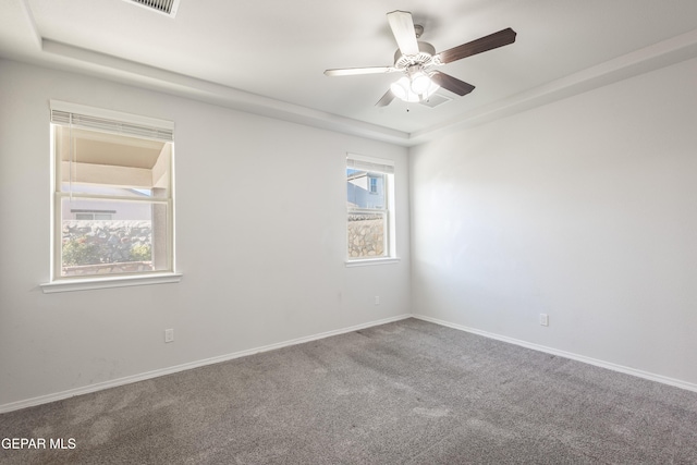 carpeted spare room with ceiling fan and baseboards