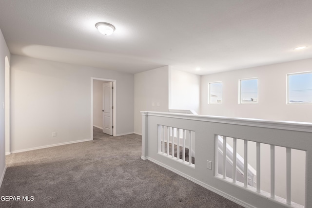 hall featuring carpet flooring, baseboards, and recessed lighting