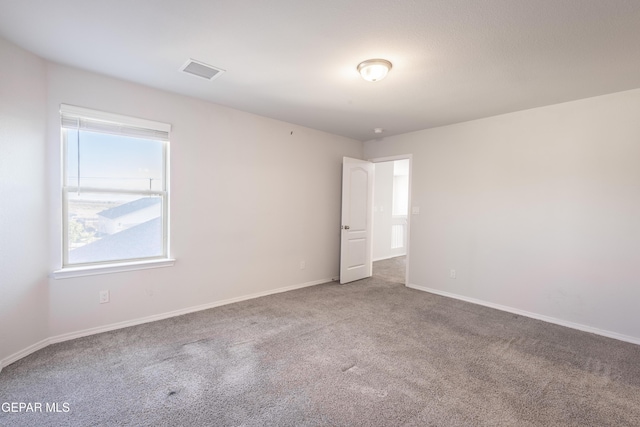 empty room featuring carpet flooring and baseboards