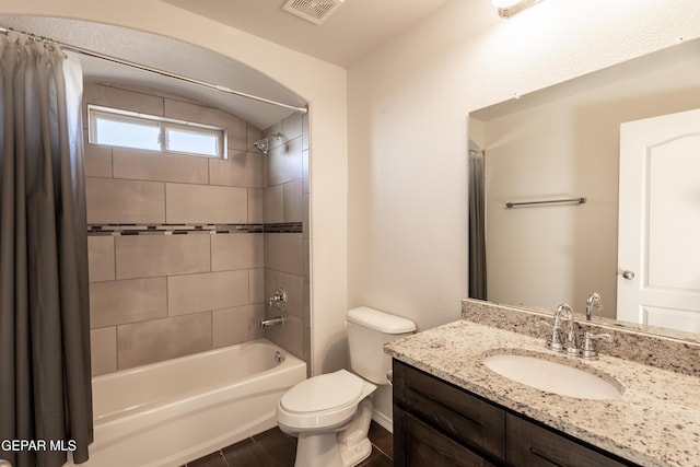 bathroom with shower / tub combo with curtain, toilet, and vanity