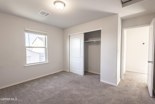 unfurnished bedroom with carpet, a closet, and baseboards
