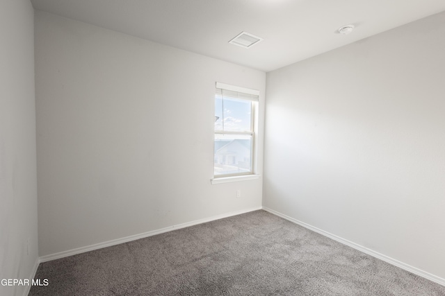 spare room featuring carpet and baseboards