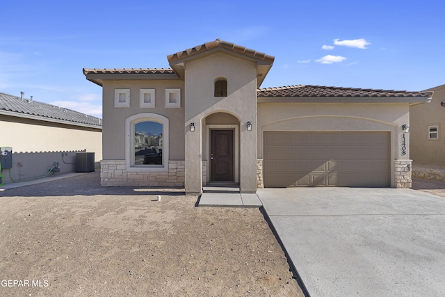 mediterranean / spanish house featuring a tile roof, central AC unit, driveway, an attached garage, and stucco siding