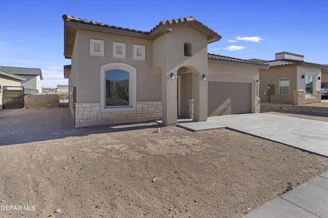 mediterranean / spanish home with a tile roof, driveway, stone siding, a garage, and stucco siding