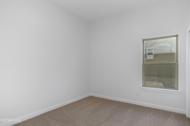 spare room with baseboards and carpet