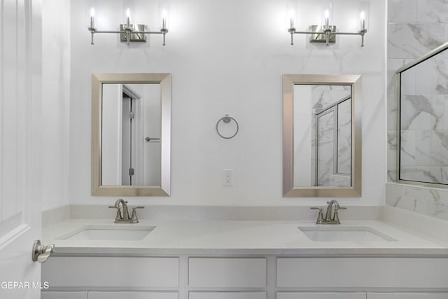 bathroom featuring a marble finish shower, a sink, and double vanity