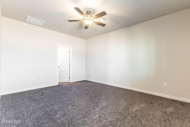 empty room featuring visible vents, ceiling fan, dark colored carpet, and baseboards