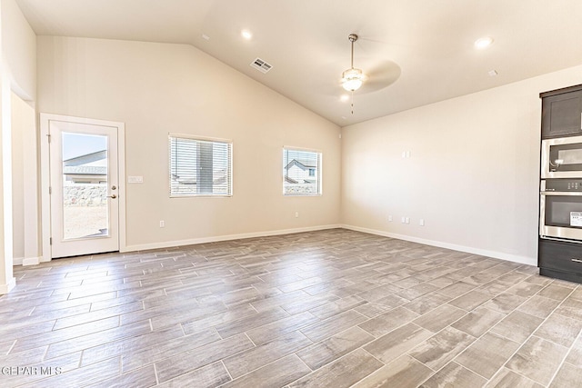 unfurnished living room featuring visible vents, ceiling fan, baseboards, light wood finished floors, and high vaulted ceiling
