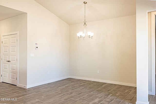 empty room with wood tiled floor, a chandelier, and baseboards