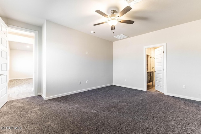 unfurnished bedroom with dark colored carpet, ceiling fan, ensuite bathroom, baseboards, and visible vents