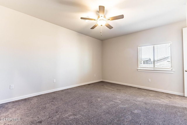 carpeted spare room featuring ceiling fan and baseboards