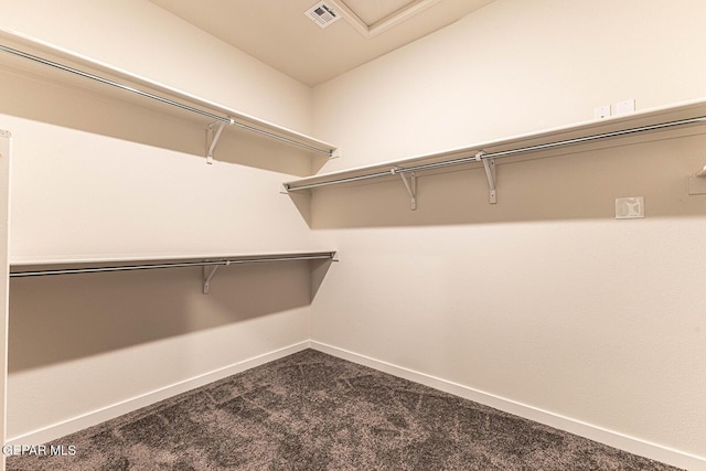 walk in closet with visible vents and dark colored carpet