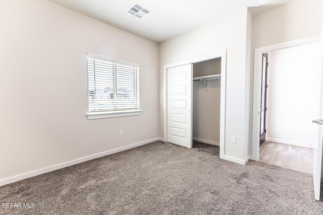 unfurnished bedroom featuring visible vents, a closet, carpet flooring, and baseboards