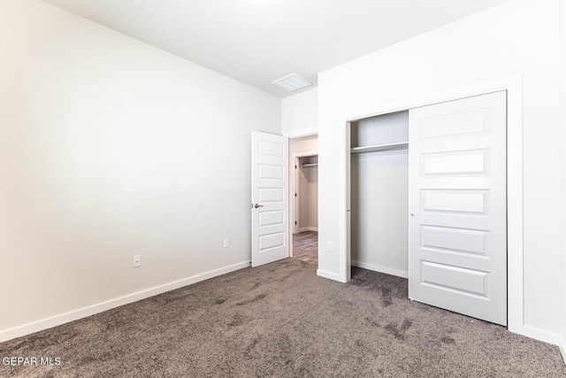 unfurnished bedroom featuring visible vents, baseboards, carpet flooring, and a closet