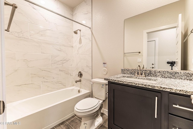 full bathroom with a textured wall, toilet, shower / washtub combination, wood finished floors, and vanity