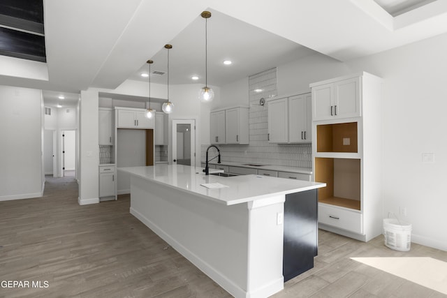 813 Durham Way, Horizon City, TX 79928 - kitchen with a sink, tasteful backsplash, light wood-type flooring, a spacious island, and baseboards