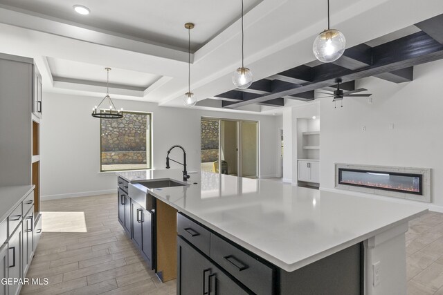 813 Durham Way, Horizon City, TX 79928 - kitchen featuring light countertops, a glass covered fireplace, a sink, and a center island with sink