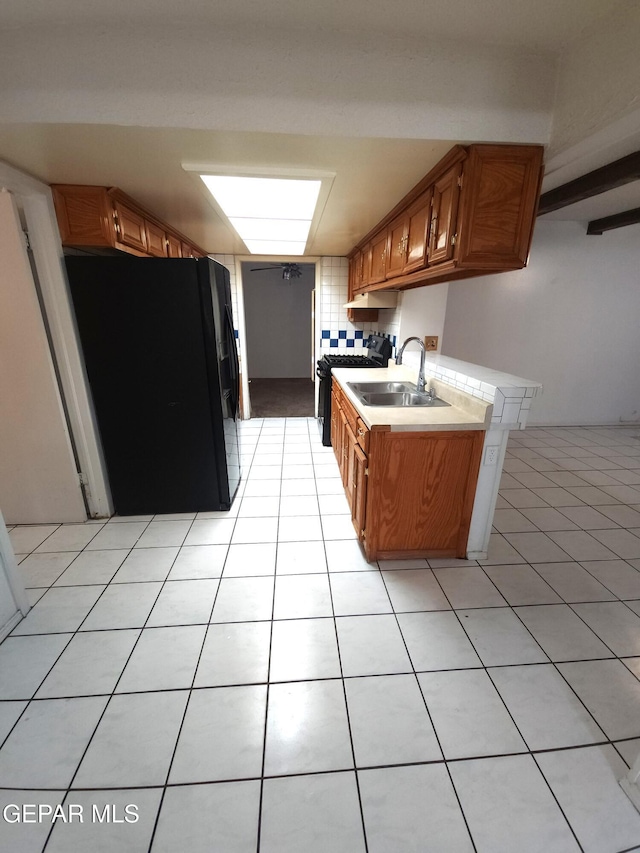 10850 Valle Grande Ct, El Paso, TX 79935 - kitchen featuring black appliances, a sink, light countertops, brown cabinetry, and light tile patterned floors