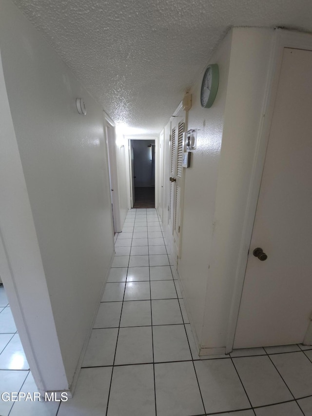 10850 Valle Grande Ct, El Paso, TX 79935 - corridor featuring a textured ceiling and light tile patterned flooring