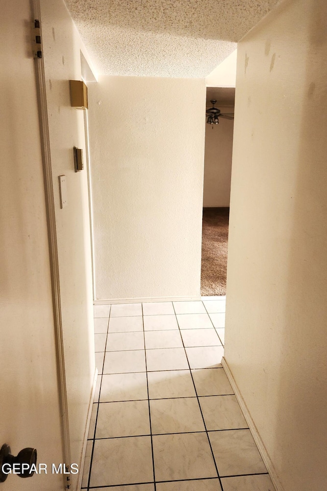 10850 Valle Grande Ct, El Paso, TX 79935 - hallway featuring light tile patterned flooring, a textured ceiling, and baseboards