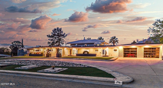 701 La Cruz Dr, El Paso, TX 79902 - view of front facade featuring curved driveway, a garage, and a lawn