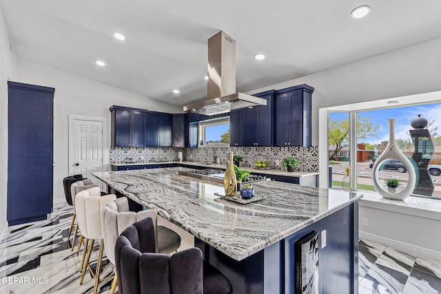 701 La Cruz Dr, El Paso, TX 79902 - kitchen with decorative backsplash, a kitchen bar, light stone counters, and island exhaust hood