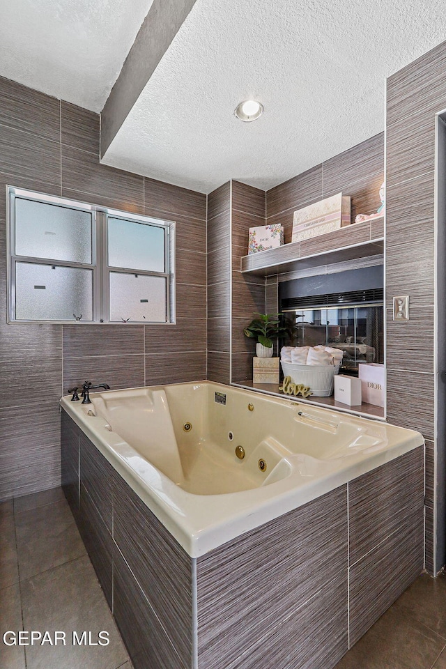 701 La Cruz Dr, El Paso, TX 79902 - full bath featuring tile patterned flooring, a textured ceiling, tile walls, and a tub with jets