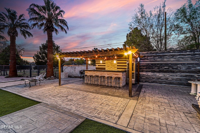 701 La Cruz Dr, El Paso, TX 79902 - patio terrace at dusk featuring fence, outdoor dry bar, and a pergola