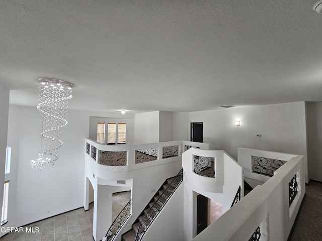 3864 Tierra Campa Dr, El Paso, TX 79938 - hall with an upstairs landing, a notable chandelier, and a textured ceiling
