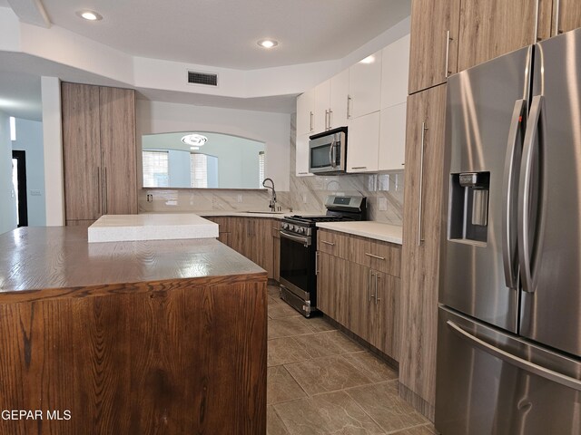 3864 Tierra Campa Dr, El Paso, TX 79938 - kitchen with white cabinets, visible vents, appliances with stainless steel finishes, a sink, and decorative backsplash