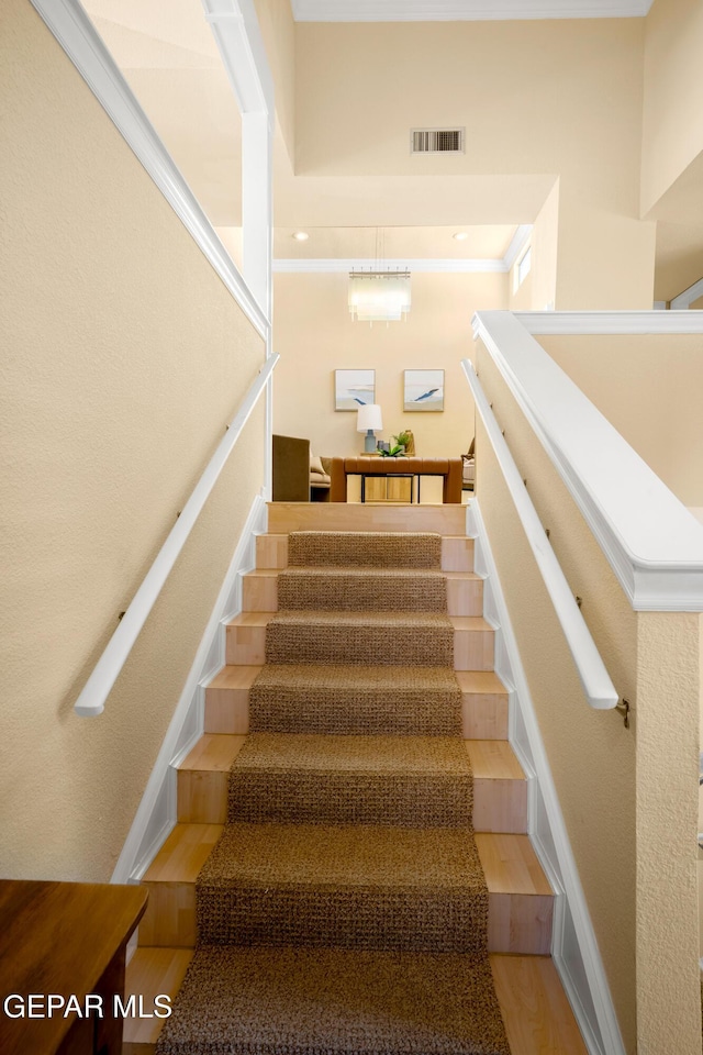 stairs featuring visible vents, baseboards, and wood finished floors