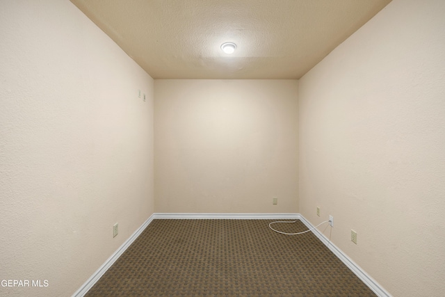 carpeted empty room featuring baseboards and a textured ceiling