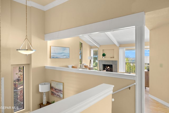 corridor with crown molding, beamed ceiling, baseboards, and wood finished floors