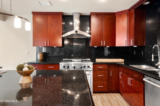 kitchen with decorative backsplash, wall chimney exhaust hood, a sink, and appliances with stainless steel finishes