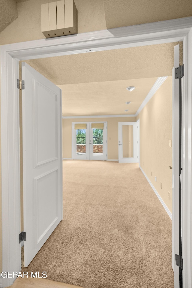 corridor with carpet, baseboards, and crown molding