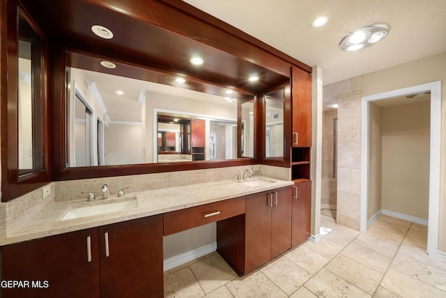 bathroom with double vanity, a sink, baseboards, and recessed lighting