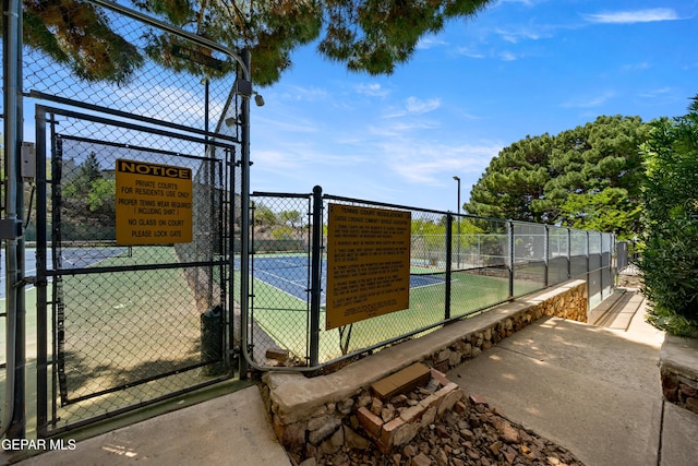 view of sport court with fence and a gate