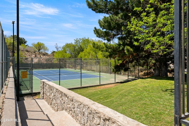 view of sport court featuring fence and a lawn