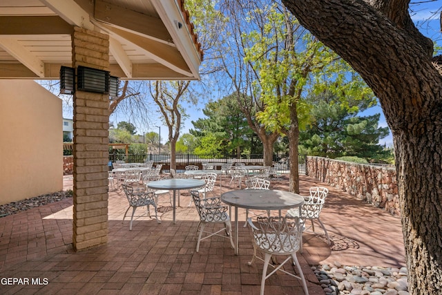 view of patio with outdoor dining space and fence