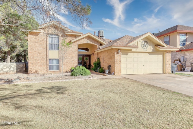 view of front facade with brick siding, french doors, an attached garage, and driveway