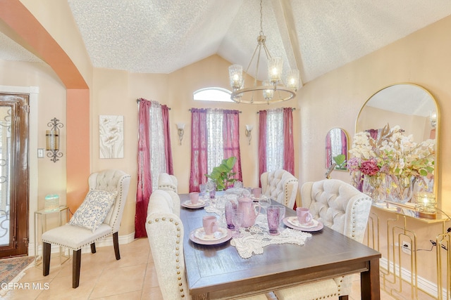 dining space with tile patterned flooring, an inviting chandelier, vaulted ceiling, arched walkways, and a textured ceiling