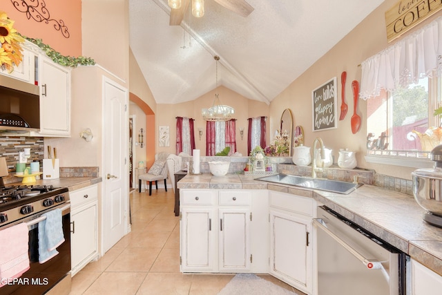 kitchen with white cabinets, stainless steel appliances, a sink, tasteful backsplash, and light tile patterned floors